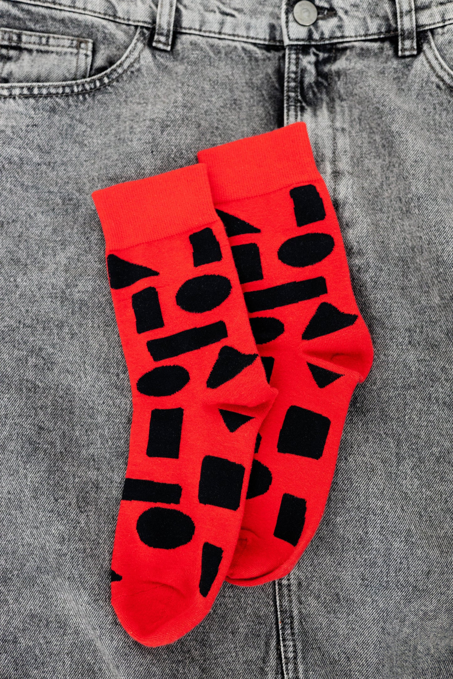 Red crew socks with bold black abstract shapes by Sarah Corynen – size 38-42 unisex cotton blend, playful geometric design for creative and colorful style.
