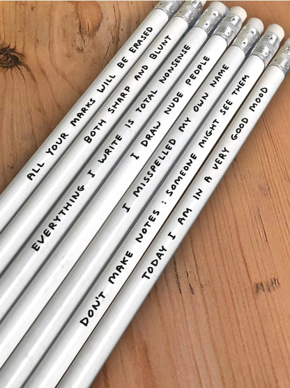 David Shrigley pencil set with 7 silver HB pencils in a yellow gift box, each featuring a humorous phrase by the British artist—ideal creative gift made in the UK for fans of quirky art and stationery.