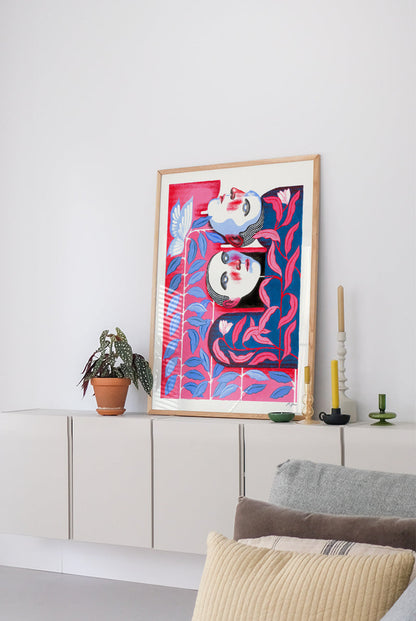 Bonding by Carla Petelski, contemporary figurative digital art print featuring two stylized faces surrounded by pink and blue botanical forms, modern emotional wall art in vibrant colors