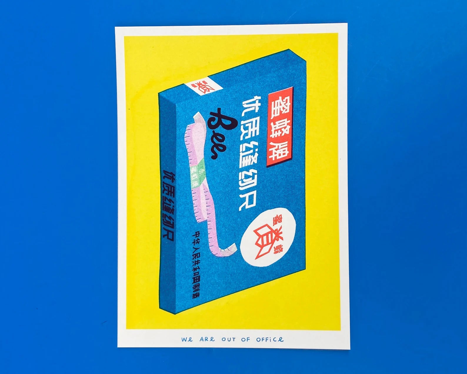 Risograph print of a Chinese Bee brand cloth measuring tape box in bright blue and yellow, created by We Are Out of Office – retro sewing supplies artwork on 300g Biotop paper.