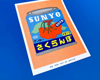 Colorful risograph art print of a Japanese can of cherries titled Canned Cherries by We Are Out Of Office, featuring bold retro typography and six-color rice-ink printing on Biotop 300g paper. Perfect wall art for pop art and Japanese design lovers.
