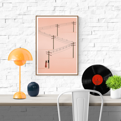 Minimalist art print titled 'Call' by Ana Yael, featuring a woman in a red dress using a vintage telephone on a wooden pole, with telephone wires stretching across a soft pink background – poetic and nostalgic wall art available at Galerie Frits