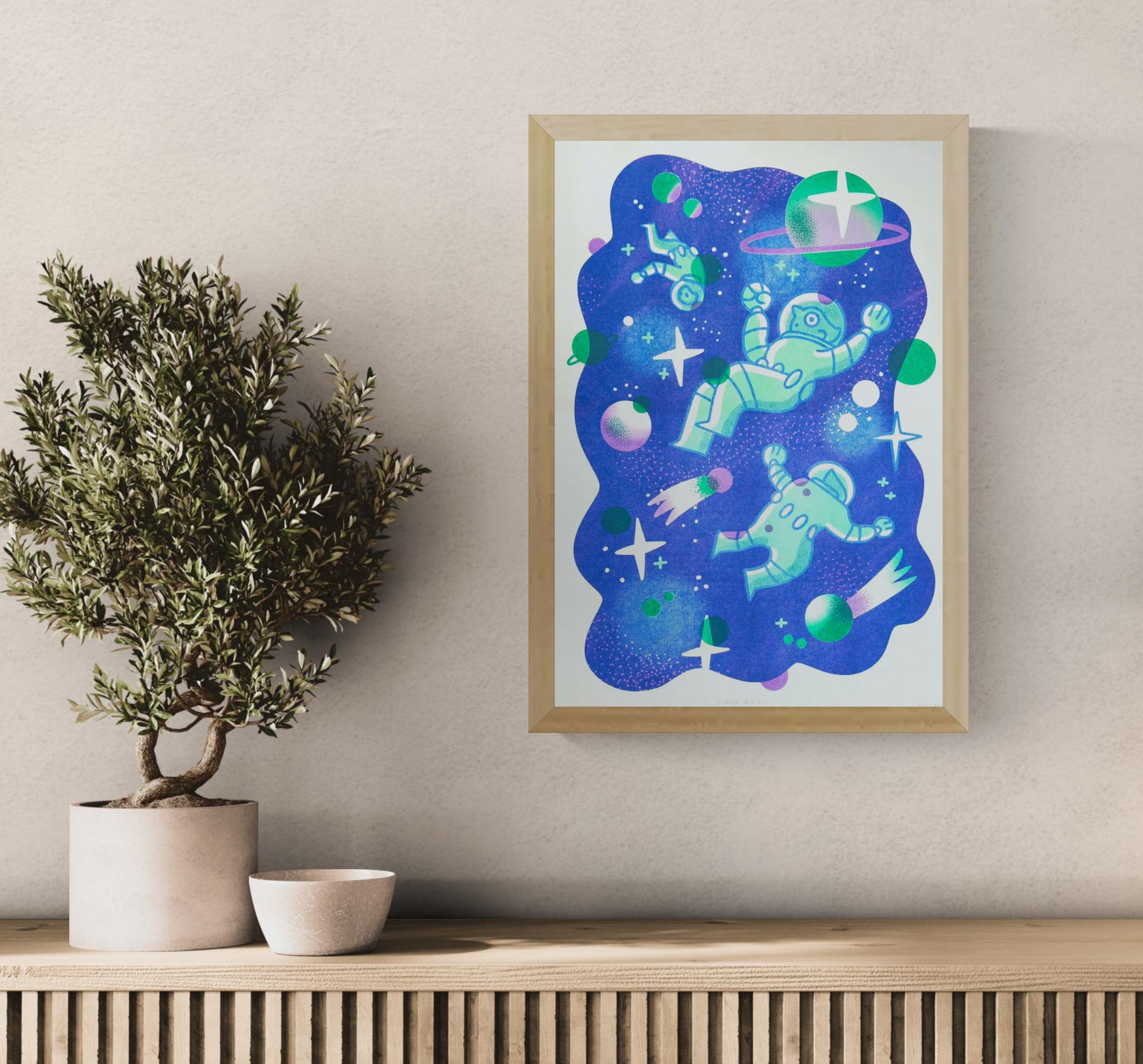 A3 limited edition risograph art print titled Space Quest by Belgian illustrator Auwnanas, featuring playful green astronauts floating in deep blue outer space with planets, stars, and graphic cosmic elements, contemporary wall art made in Belgium.