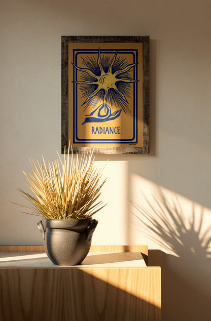 Radiance linocut print by Belgian artist Leda Vaes featuring a golden abstract sun with blue rays and a hand illustration on handmade paper in A4 format.