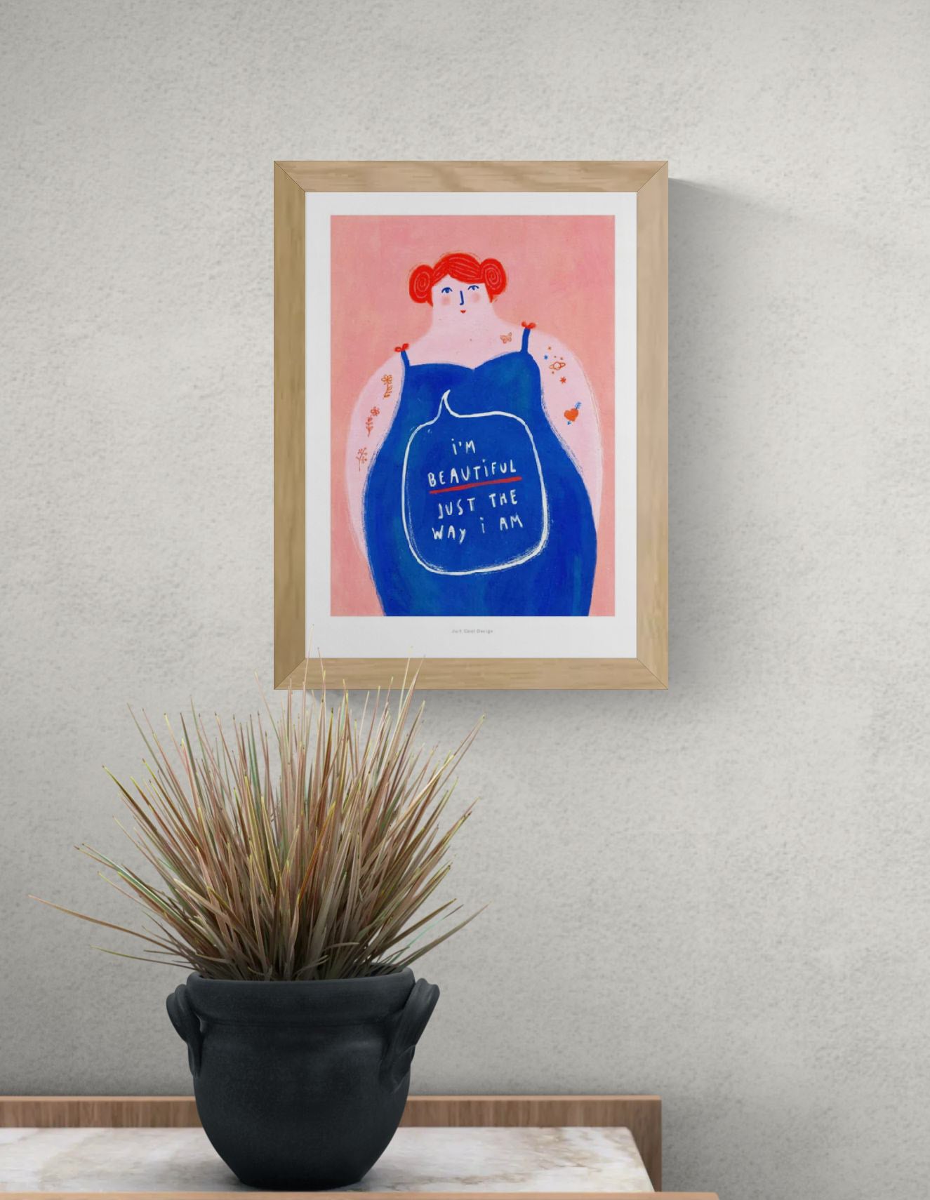 Colorful feminist illustration of a confident woman with red hair and a blue dress, featuring the message “I’m beautiful just the way I am”, body positivity art print by Just Cool Design.