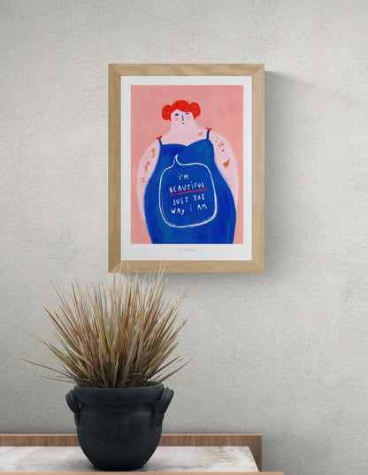 Colorful feminist illustration of a confident woman with red hair and a blue dress, featuring the message “I’m beautiful just the way I am”, body positivity art print by Just Cool Design.