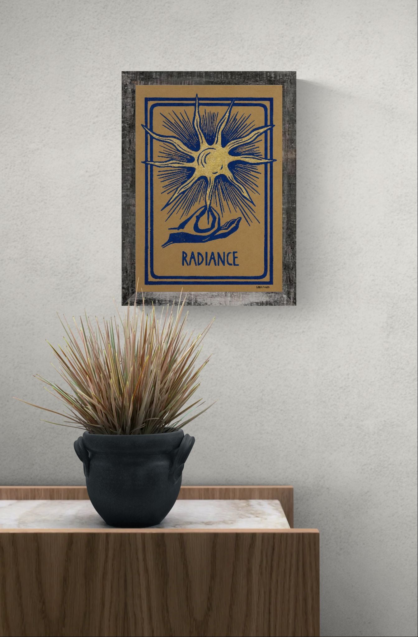 Radiance linocut print by Belgian artist Leda Vaes featuring a golden abstract sun with blue rays and a hand illustration on handmade paper in A4 format.