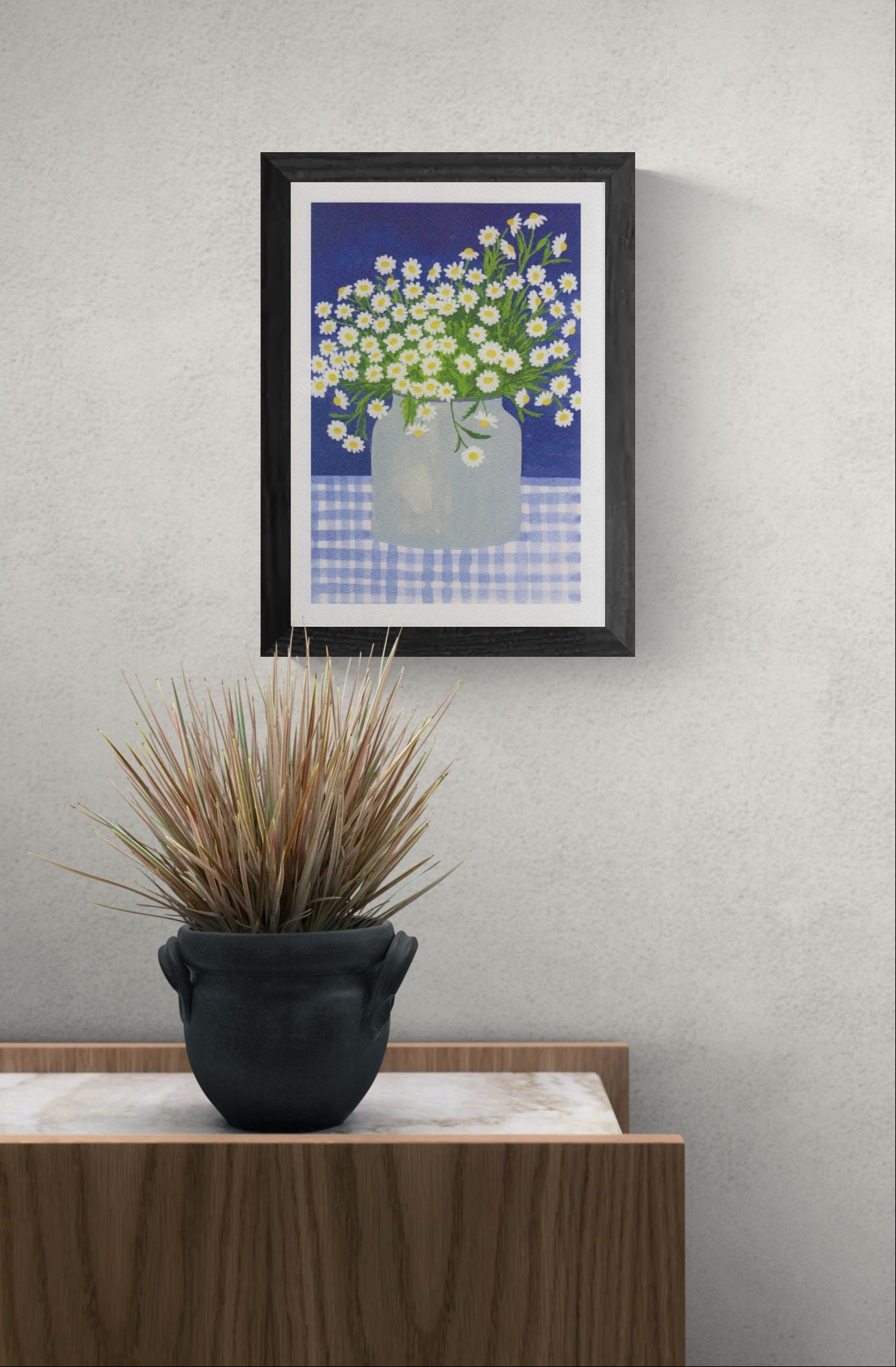 Hand-illustrated art print titled “Daisies” by Belgian artist Leens, featuring a lush bouquet of white daisies with yellow centers in a transparent jar, placed on a blue gingham tablecloth with a deep blue background. Printed on A4 textured fine art paper.