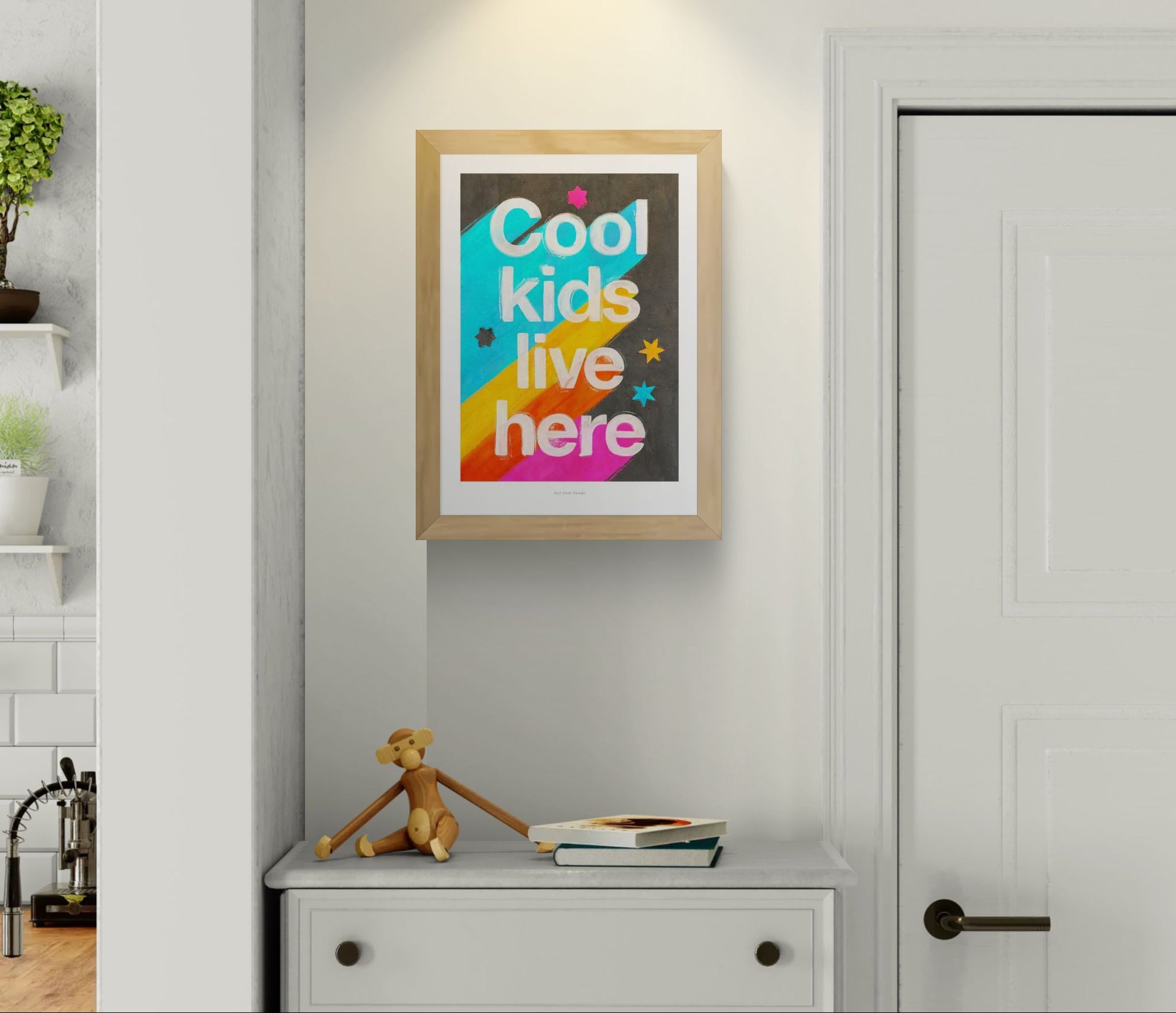 Giclée art print by Just Cool Design with the phrase "Cool kids live here" in bold white letters over a bright rainbow background with stars, ideal for colorful children's rooms or playful modern decor.