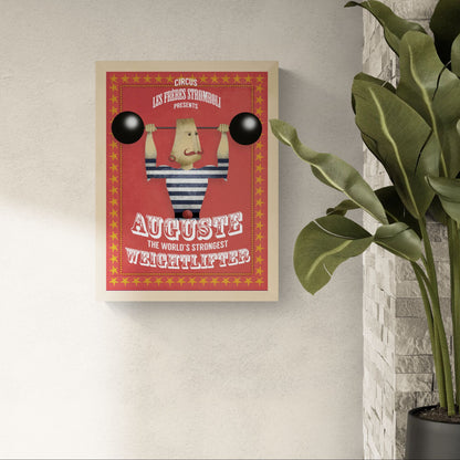 Playful vintage-style illustration by Studio Frits titled 'Auguste Stromboli,' designed as a fictional circus poster featuring a strongman in a striped suit lifting cartoonishly large barbells. Surrounded by red and yellow star borders with bold typography, this whimsical artwork channels classic circus charm—perfect for eclectic interiors, children's rooms, or collectors of retro-inspired prints