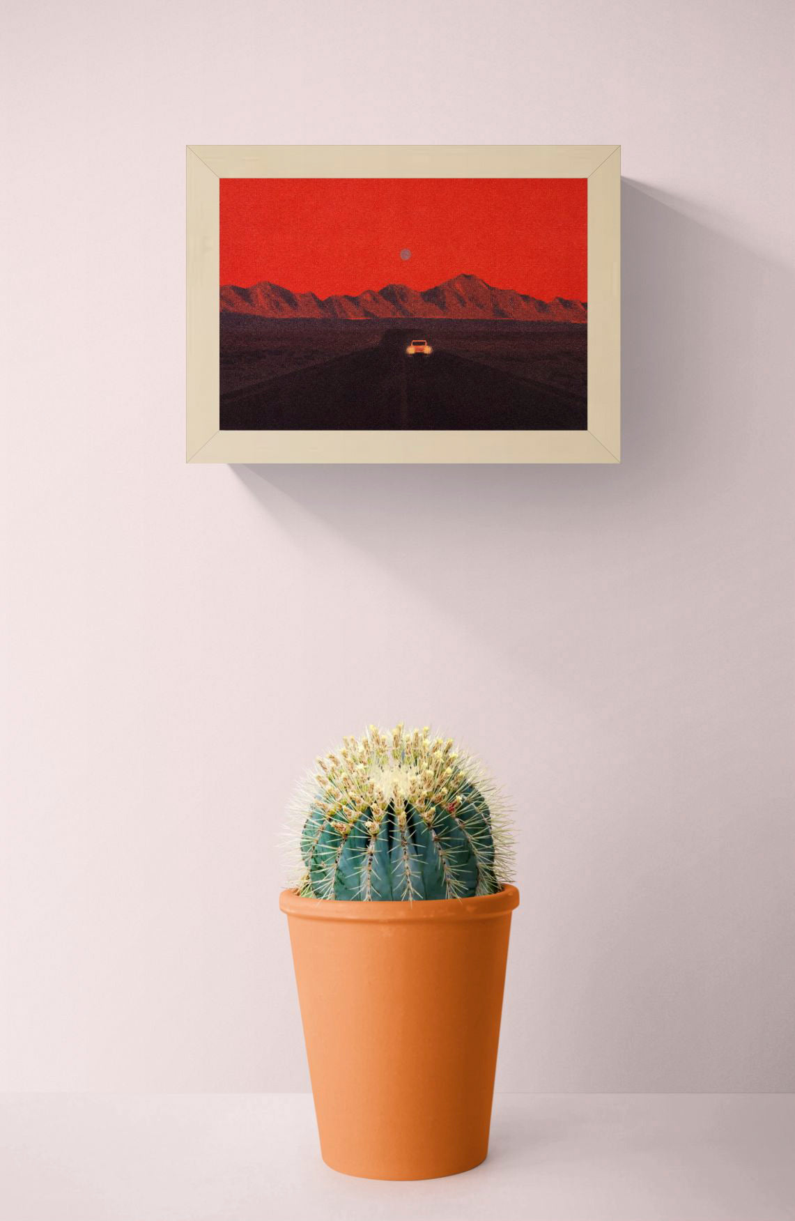 Namibia by Linde Raats, horizontal A6 giclée print showing a car driving toward dark mountains beneath a textured red sky, atmospheric wall art for modern home decor.