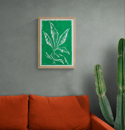 Handmade green botanical linocut print titled Vers by Belgian artist Leda Vaes featuring abstract tropical leaves and a hand in bold carved lines on textured paper, contemporary nature-inspired wall art in A3 format.