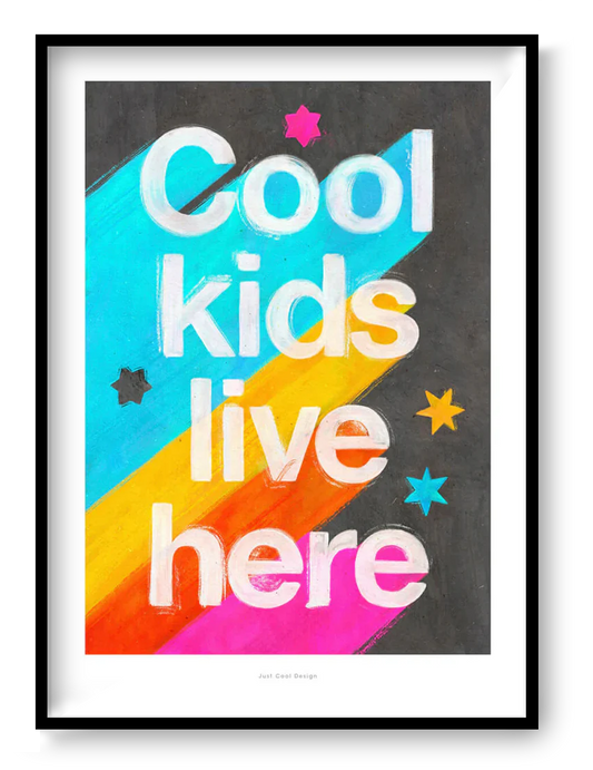 Giclée art print by Just Cool Design with the phrase "Cool kids live here" in bold white letters over a bright rainbow background with stars, ideal for colorful children's rooms or playful modern decor.