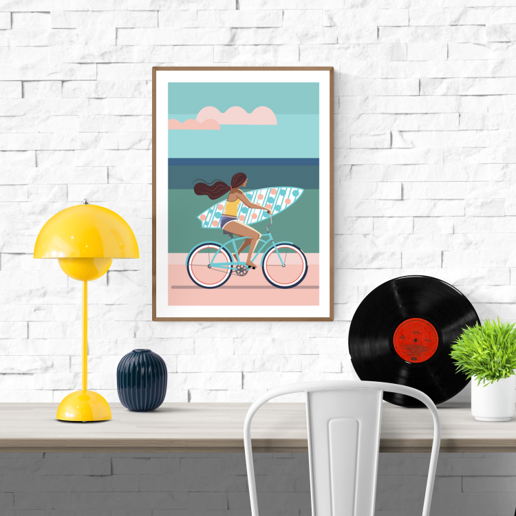 Illustration of a woman cycling along a beach with a surfboard under her arm on a sunny day – Perfect day by Floor 4 Productions, A3 art print made in Belgium.