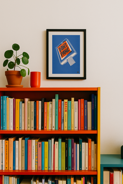 Risograph art print titled Book by VrijFormaat, featuring a blue book cover with bold red and black lettering reading “DON’T PANIC”, inspired by The Hitchhiker’s Guide to the Galaxy. Minimalist design printed in red and blue vegetable-based inks on Biotop paper, A4 size.