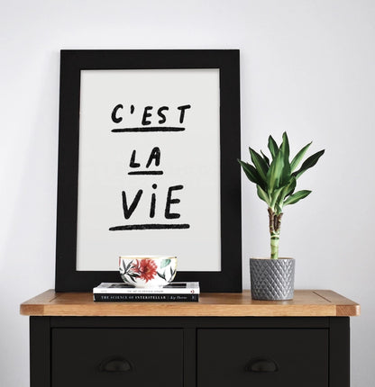 Black and white minimalist art print with handwritten French quote 'C'est la vie' by Just Cool Design – modern typography wall art for contemporary interiors, available at Galerie Frits