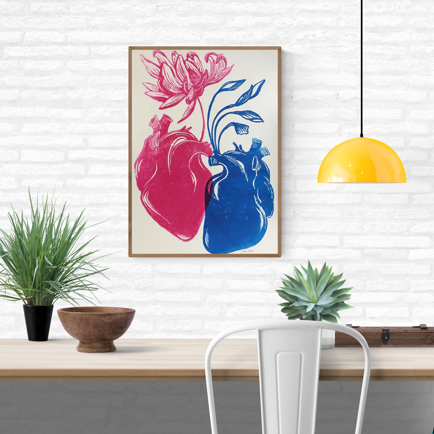 Handmade linocut print ‘Rebirth’ by Belgian artist Leda Vaes featuring a pink anatomical heart blooming into a flower and a blue heart growing flowing leaves, symbolizing renewal, connection, and new beginnings; high-contrast artistic print on textured paper.