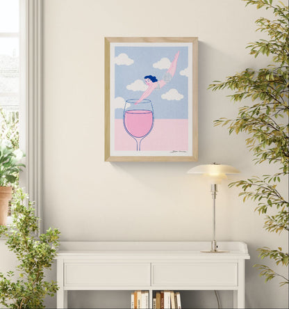 Playful risograph print of a woman diving into a glass of pink wine beneath white clouds, illustrated in pastel pink and blue with a contemporary graphic style, ideal for kitchen, dining room, or modern home decor.