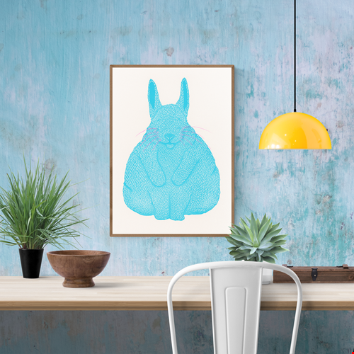 Risograph art print titled Siesta by Strangford, featuring a turquoise blue bunny with pink whiskers curled in a peaceful nap, printed on eco-friendly A3 recycled paper in Northern Ireland.
