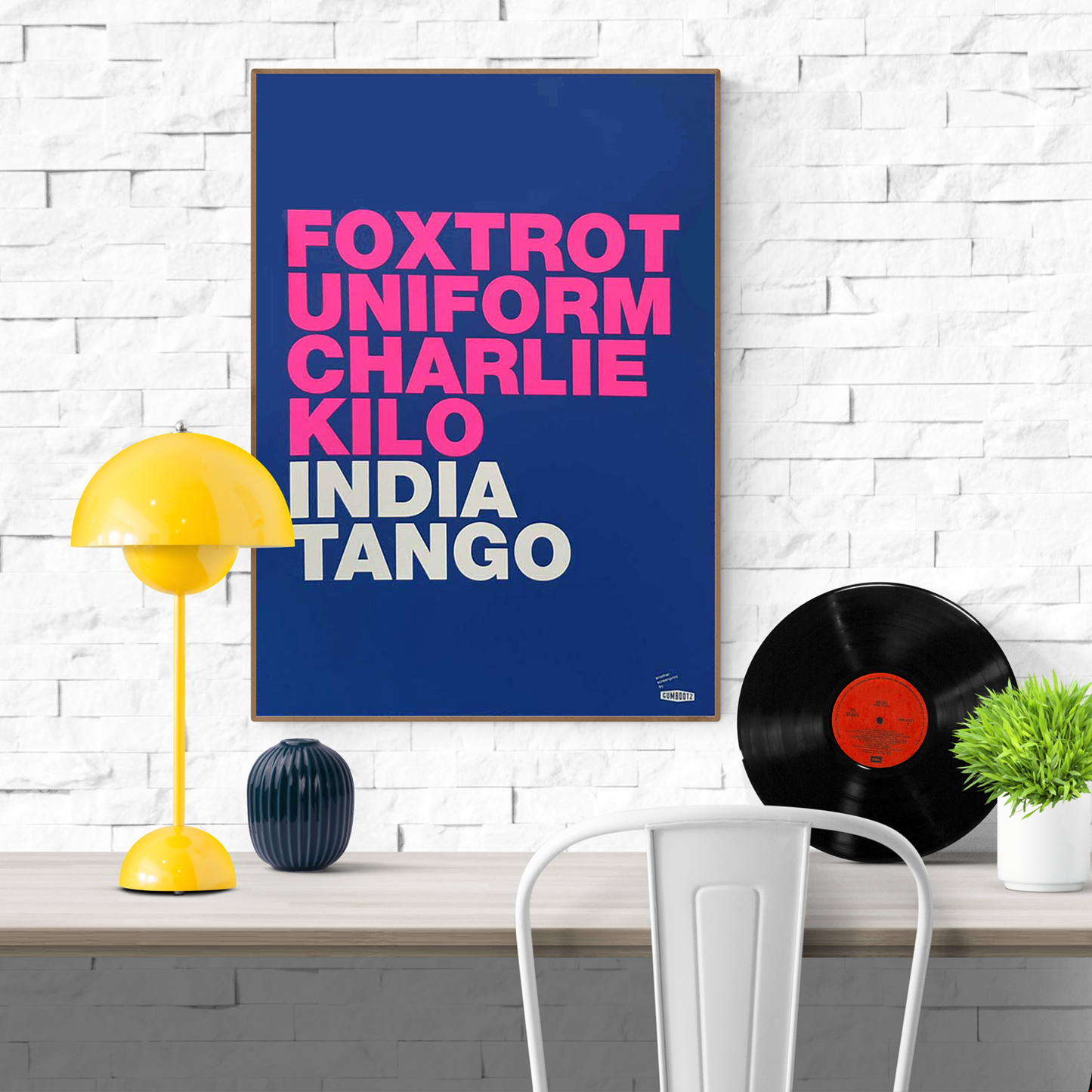 Large blue screen print with bold pink and white typography spelling 'Foxtrot Uniform Charlie Kilo India Tango' by Dutch artist Gumbootz — modern statement art poster, ideal for contemporary spaces.
