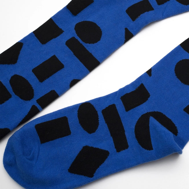 Blue crew socks with bold black abstract shapes by Sarah Corynen – limited edition cotton blend, unisex size 38-42, artistic and fun design for everyday wear.