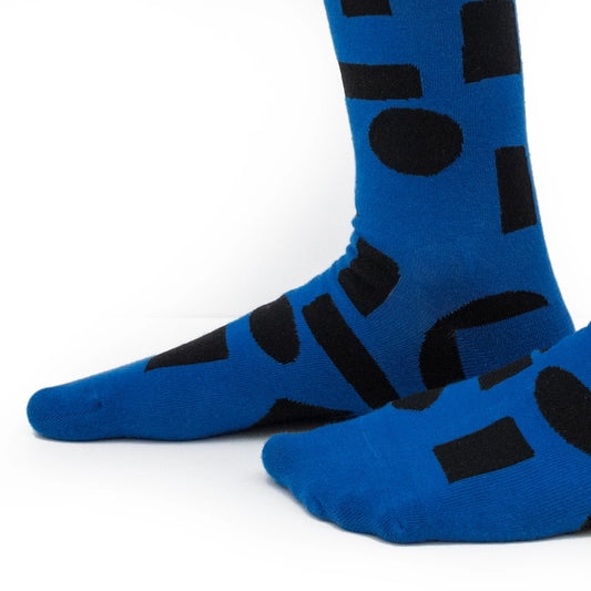 Blue crew socks with bold black abstract shapes by Sarah Corynen – limited edition cotton blend, unisex size 38-42, artistic and fun design for everyday wear.
