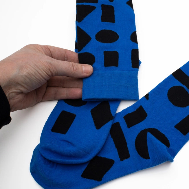 Blue crew socks with bold black abstract shapes by Sarah Corynen – limited edition cotton blend, unisex size 38-42, artistic and fun design for everyday wear.