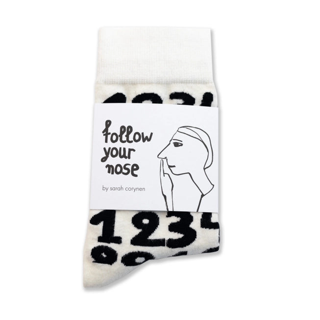 White crew socks with bold black numbers by Sarah Corynen – unisex cotton socks in size 38-42, playful illustrated design for math lovers and quirky everyday style.