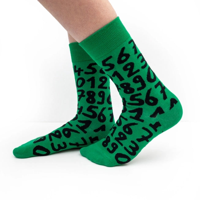 Green crew socks with playful black numbers by Sarah Corynen – unisex cotton blend, size 38-42, bold and quirky design for math fans and creative wardrobes.