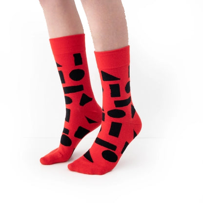 Red crew socks with bold black abstract shapes by Sarah Corynen – size 38-42 unisex cotton blend, playful geometric design for creative and colorful style.