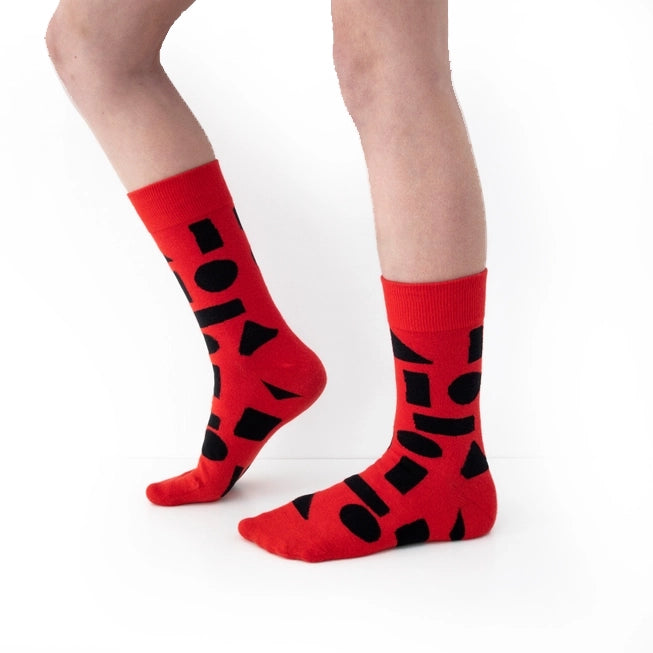 Red crew socks with bold black abstract shapes by Sarah Corynen – size 38-42 unisex cotton blend, playful geometric design for creative and colorful style.