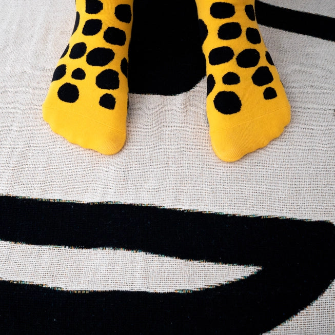 Bold yellow crew socks with playful black polka dots by Sarah Corynen – size 38-42, unisex, cotton blend, fun illustrated design for colorful everyday wear.