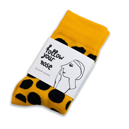 Bold yellow crew socks with playful black polka dots by Sarah Corynen – size 38-42, unisex, cotton blend, fun illustrated design for colorful everyday wear.