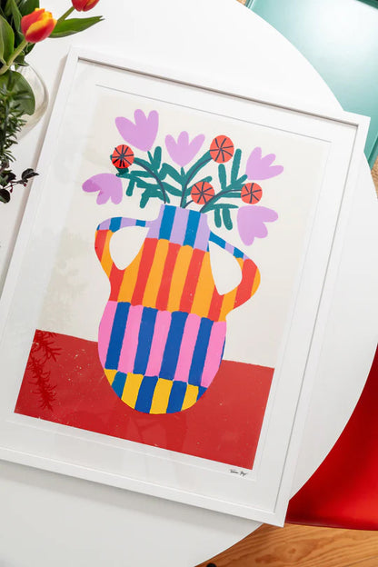 “Striped Vase With Handles” by Teresa Rego – vibrant A4 fine art print featuring a multicolored striped vase with blooming red and lavender flowers, printed on high-quality Munken Pure paper. Colorful wall décor made in Portugal.