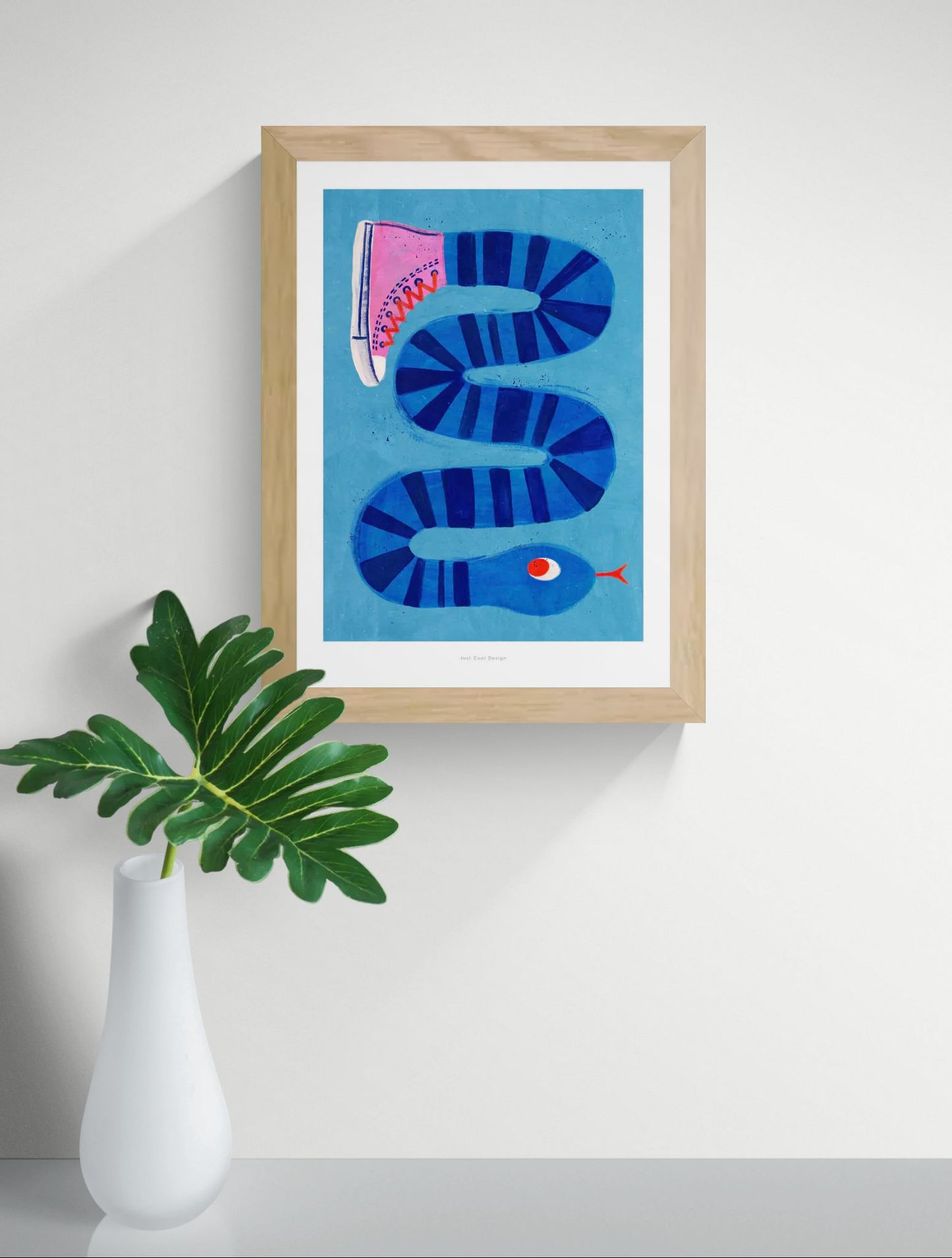 Colorful surreal illustration print by Just Cool Design featuring a long blue striped snake wearing a single pink sneaker, set against a bright blue background. Modern, quirky wall art for playful interiors and design lovers.