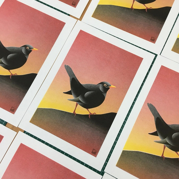 Blackbird illustration by VrijFormaat featuring a sleek black bird against a warm sunset gradient background — modern nature-inspired wall art available at Galerie Frits