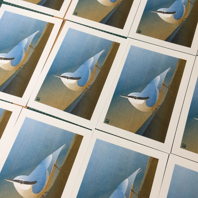 Illustration of a stylized nuthatch bird clinging to a tree in minimalist, soft blue and ochre tones – Nuthatch by VrijFormaat, A4 risograph art print made in the Netherlands.