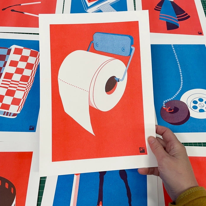 Minimalist risograph art print of a toilet paper roll in bold red and blue by VrijFormaat. Modern pop-art style wall art celebrating everyday design objects. Printed on Biotop 160g paper, A4 size, made in the Netherlands.
