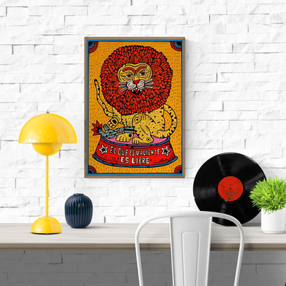 A3 art print titled Valentia by Spanish illustrator Asis Percales, featuring a cartoon-style lion with exaggerated red mane breaking a chain, sitting on a circus pedestal that reads "El que es valiente es libre" in bold red and yellow colors. Tattoo-inspired, eccentric, and full of symbolic energy. Made in Spain on 250g paper.