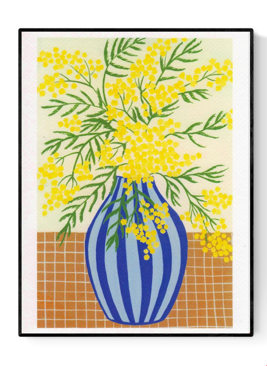 Botanical digital art print titled “Mimosa” by Belgian illustrator Leens, featuring vibrant yellow mimosa flowers in a blue striped vase on a tiled table, printed on textured fine art paper in A4 size.