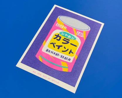 Colorful risograph art print titled Japanese Bucket of Paint by Dutch duo We Are Out Of Office, featuring a retro Japanese paint can in bright fluorescent pink, purple, and yellow tones. Hand-printed with rice-based inks on Biotop 300g paper, perfect for pop art and design lovers.