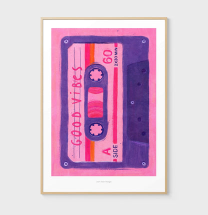 Colorful Giclée art print of a retro pink and purple cassette tape labeled “Good Vibes,” designed by Just Cool Design. 80s-inspired wall art that adds cheerful, nostalgic energy to modern interiors—perfect for music lovers and vintage decor fans.