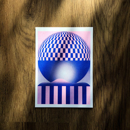 Pink and blue geometric risograph print by Dutch illustrator PTRVRKD – abstract optical landscape with checkerboard sphere, striped base, and dreamy gradient design, printed with eco-friendly soy inks on 250 gsm Biotop paper, handmade in the Netherlands – bold modern wall art for graphic design enthusiasts.