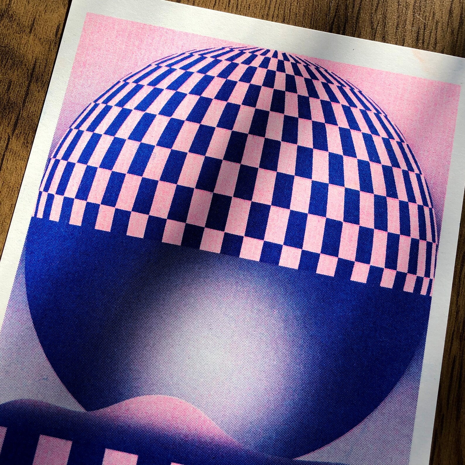 Pink and blue geometric risograph print by Dutch illustrator PTRVRKD – abstract optical landscape with checkerboard sphere, striped base, and dreamy gradient design, printed with eco-friendly soy inks on 250 gsm Biotop paper, handmade in the Netherlands – bold modern wall art for graphic design enthusiasts.