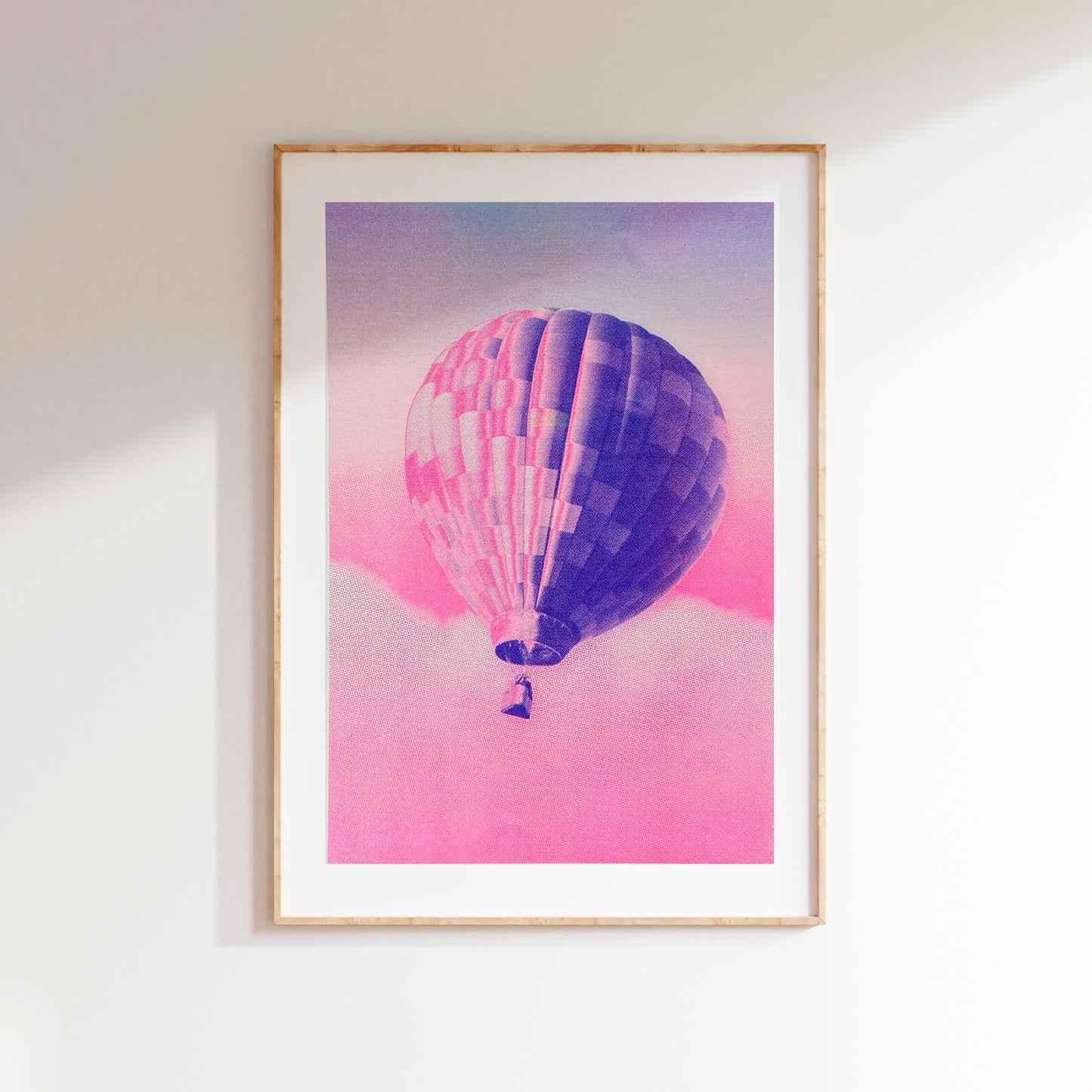 A3 risograph print of a pink and blue hot air balloon floating over dreamy clouds by PTRVRKD, hand-printed on 300 gsm Biotop paper.