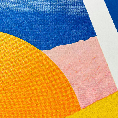 Minimalist desert art print with bold yellow sun and African dune landscape in vivid blue, orange, and peach tones by Dutch artist PTRVRKD – A3 risograph print, limited edition, eco-friendly ink.