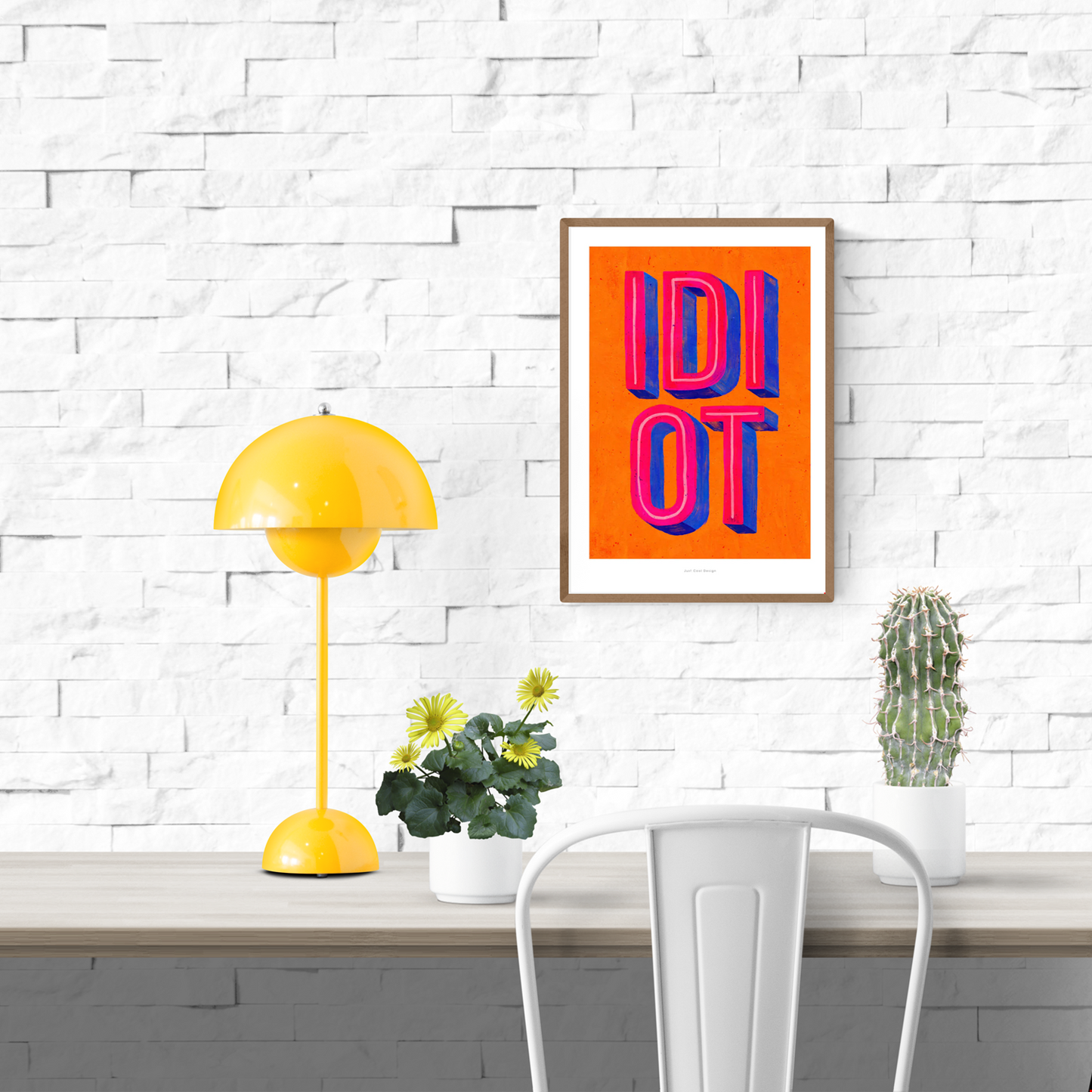 Colorful giclée art print by Just Cool Design featuring the word “IDIOT” in bold 3D-style typography with vibrant pink and blue letters on a bright orange background.