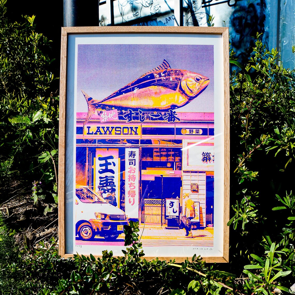 Vibrant risograph print of a Japanese Lawson store with oversized tuna sculpture on top, created by PTRVRKD in CMYK on A3 Biotop paper. Limited edition art print with bold pink, yellow, and blue tones, hand-signed and numbered.