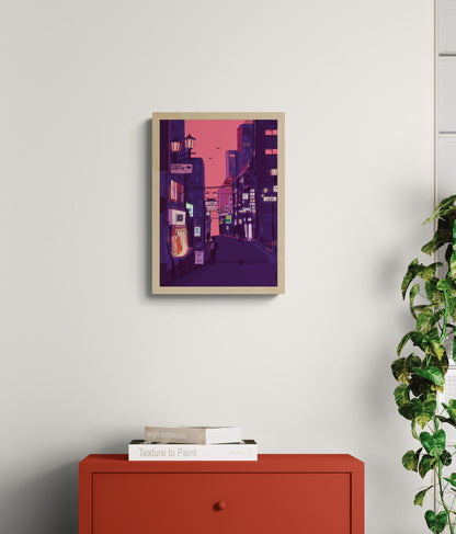 Fine art giclée print titled “Nights in Japan” by Valeria Maggiani featuring a cinematic Japanese city street at dusk with neon signs, warm shop lights, urban silhouettes, and a pink-purple evening sky, printed on 100% cotton textured paper A4 size, ideal for modern home decor and contemporary wall art in Belgium and Europe.