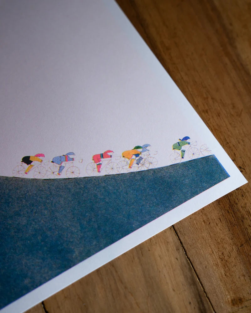 Four-color risograph art print La montée by Viola Amman showing colorful cyclists climbing a steep green hill against a pale background. Minimalist, playful wall art full of motion and optimism, ideal for cycling lovers and modern interiors.